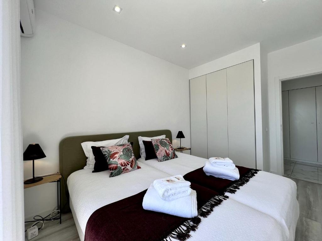 a bedroom with two beds with towels on them at Faro Deluxe by Homing in Faro