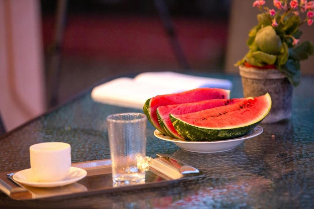 een tafel met een kom watermeloen en een glas bij Evita home karavados in Karavádhos