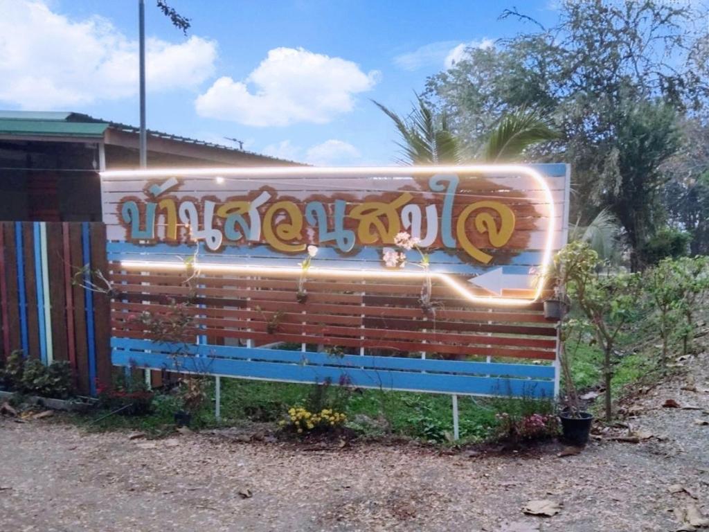 a bench covered in graffiti in front of a house at บ้านสวนสุขใจ รีสอร์ท in Ban Makok