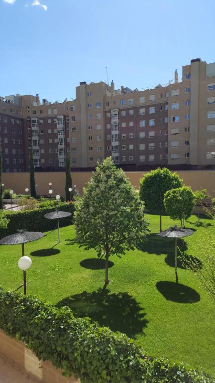 ein Park mit Bäumen und Gras mit Gebäuden im Hintergrund in der Unterkunft Madrid Las Tablas apartments in Madrid
