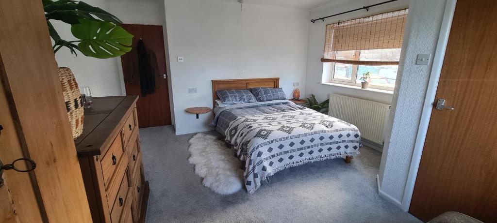 a bedroom with a bed with a comforter and a window at The Cornish Getaway in Newquay