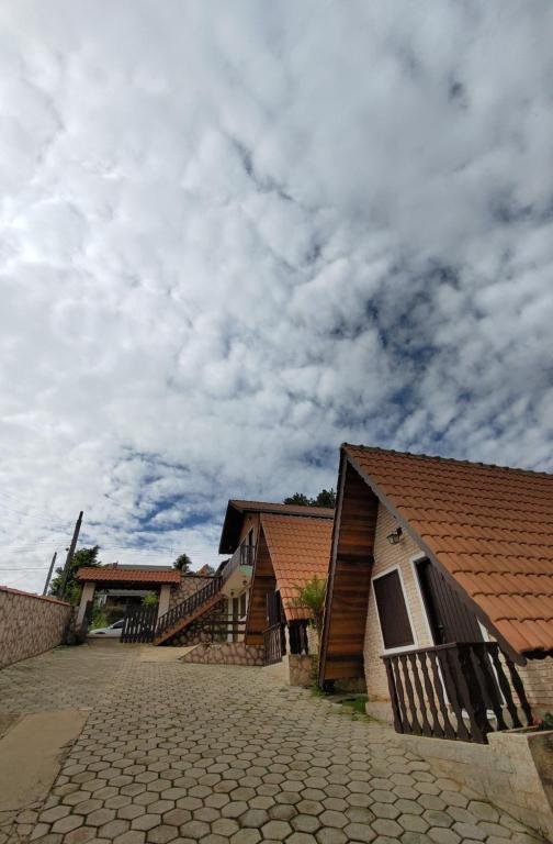 a row of buildings with a cloudy sky in the background at Pousada Florada da Serra in Monte Verde