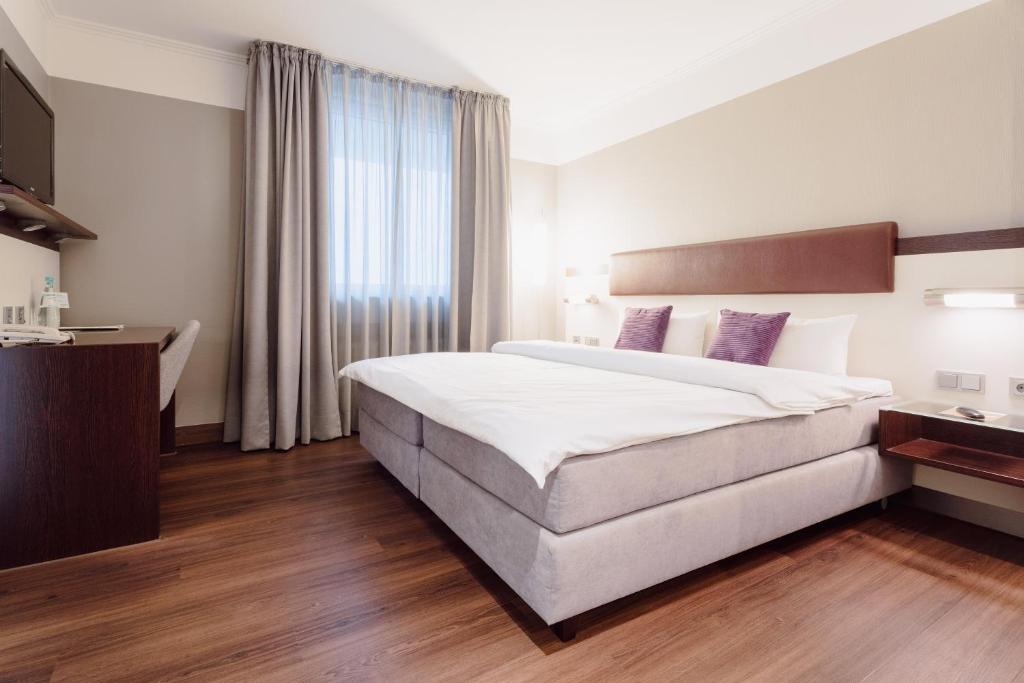 a hotel room with a large bed and a window at Hotel Kaiserhof in Münster