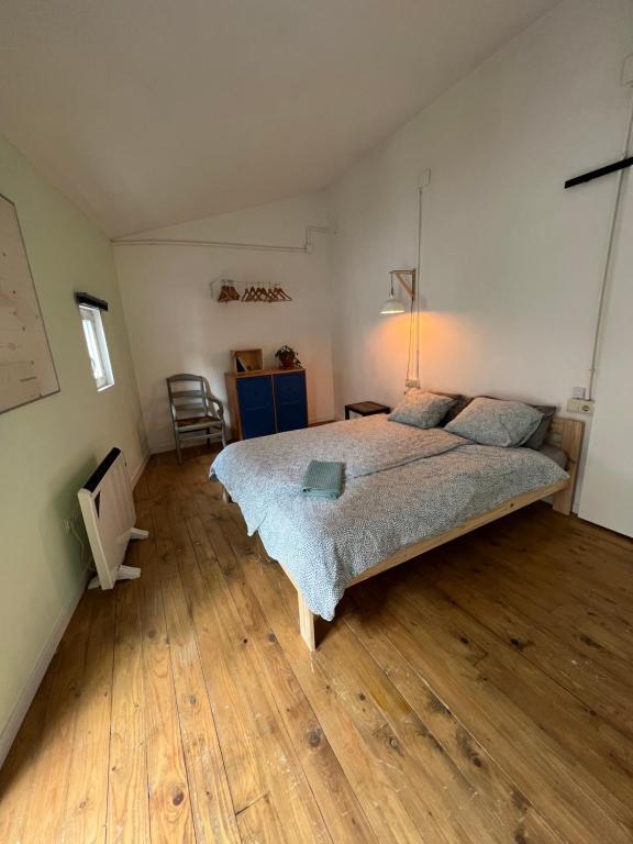 - une chambre avec un grand lit et du parquet dans l'établissement Precioso apartamento en el centro de Esparreguera, à Esparraguera