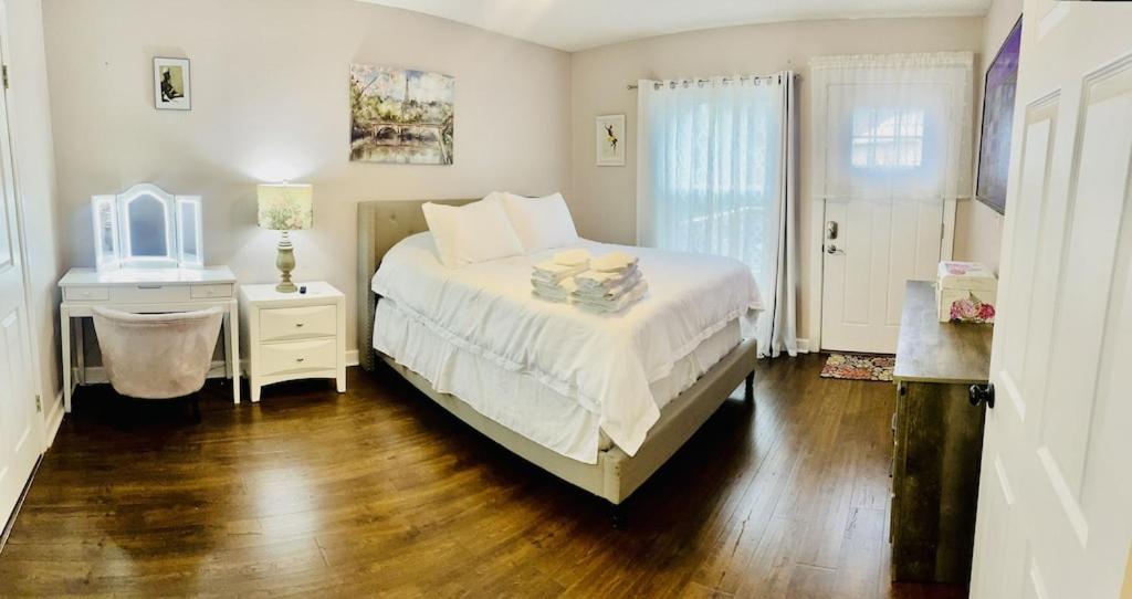Schlafzimmer mit einem Bett und einem Tisch mit einem Spiegel in der Unterkunft Eclectic 3 bedroom townhouse with back terrace in Tallahassee