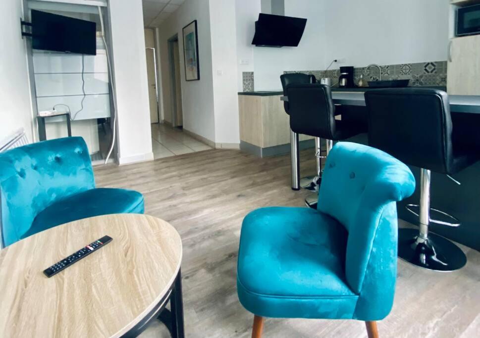 - un salon avec des chaises bleues, une table et un bureau dans l'établissement *Bleu Saphir* centre de Vichy, à Vichy