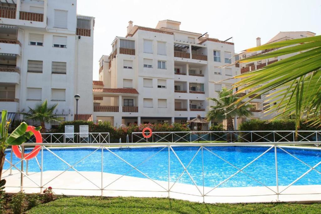 una piscina di fronte ad alcuni edifici di 2BDR Sunny apartment with pool and private parking in Benalmádena a Benalmádena