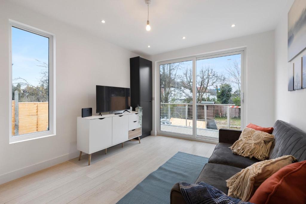 a living room with a couch and a tv at Star London Station Road 3-Bed Oasis with Garden in The Hyde