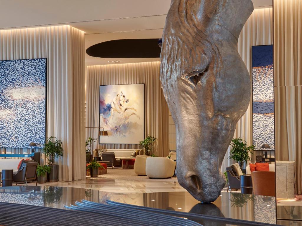 een lobby met een standbeeld van een hoofd op een tafel bij Grand Hyatt Kuwait in Koeweit