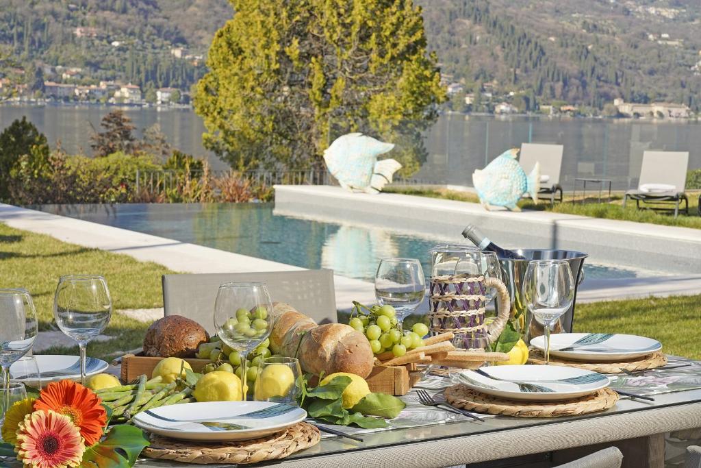una mesa con un plato de comida y copas de vino en Villa Bianca directly on the lake modern amazing, en San Felice del Benaco