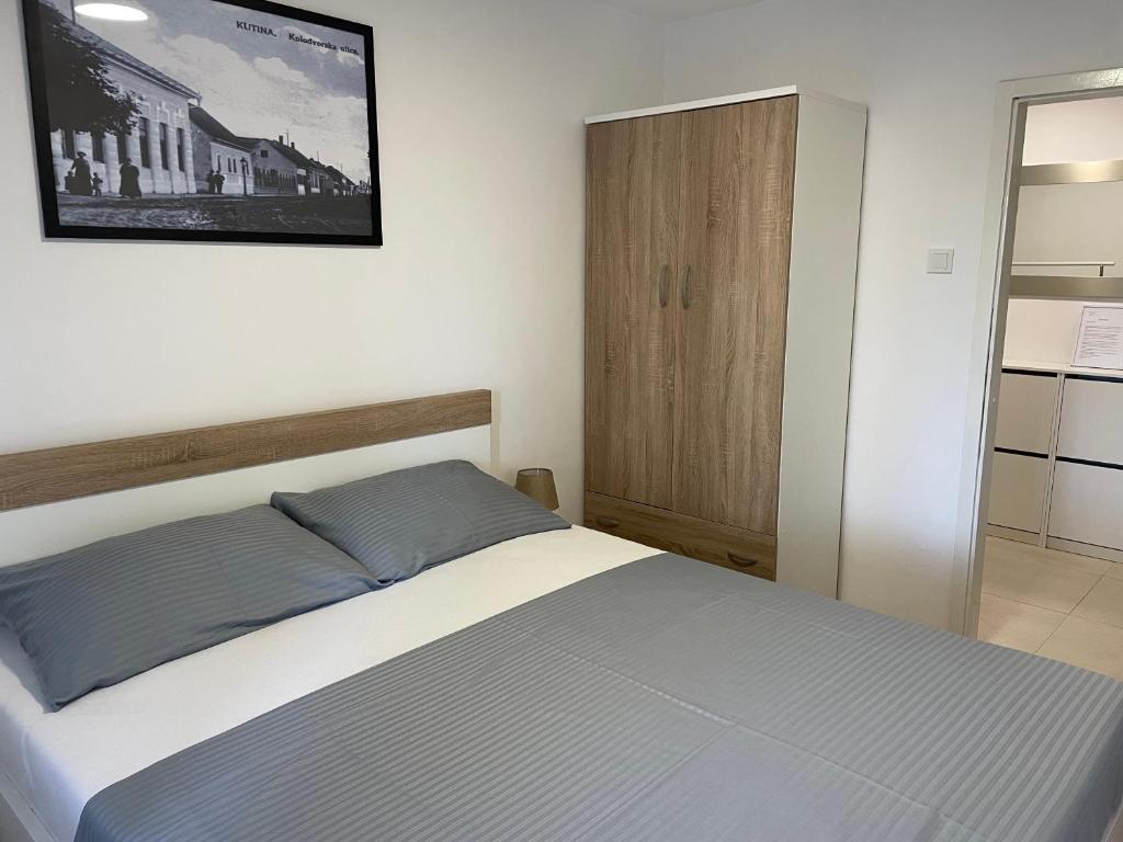 um quarto com uma cama e uma fotografia na parede em Apartman Danica em Kutina