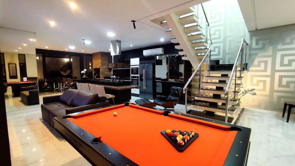 a living room with an orange pool table in it at Casa Luxo Jacuzzi aquecida prox Cataratas e Aerpt in Foz do Iguaçu