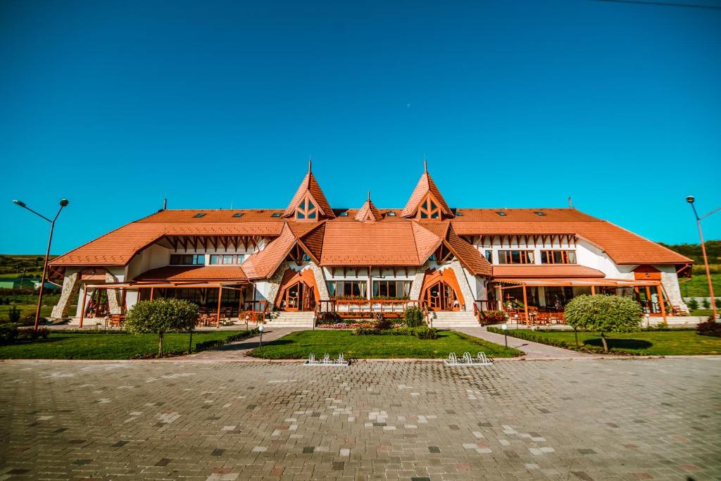 un gran edificio de madera con techo rojo en Bonanza Pensiune & Restaurant, en Cluj-Napoca