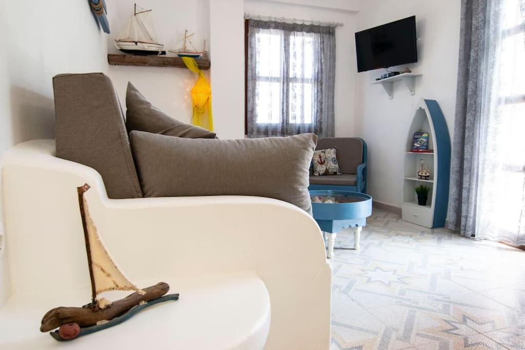 un soggiorno con divano bianco e TV di Fisherman's Lodge a Karpathos