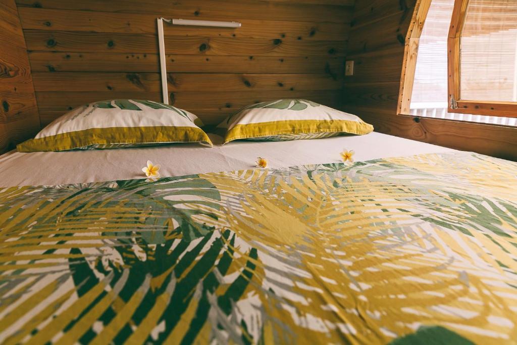 a bed in a room with two pillows on it at Le Myranoa, bungalow/tonneau in Saint-Pierre