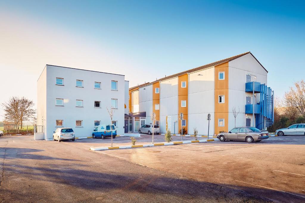 a parking lot with cars parked in front of a building at Première Classe Amiens in Amiens