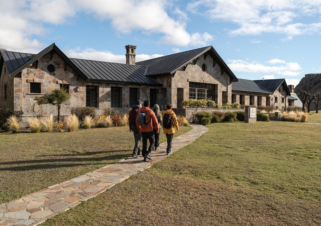 a group of people walking towards a stone house at Explora en Parque Nacional Patagonia in Cochrane