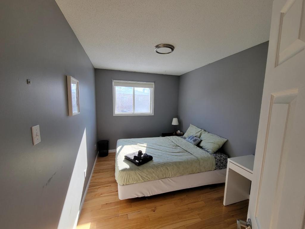 niewielka sypialnia z łóżkiem i oknem w obiekcie Comfy Private Bedroom near Downtown Ottawa/Gatineau w mieście Gatineau