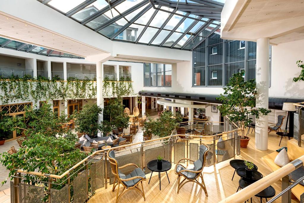 an openrium with chairs and plants in a building at Precise Resort Marina Wolfsbruch - Familienapartments in Rheinsberg