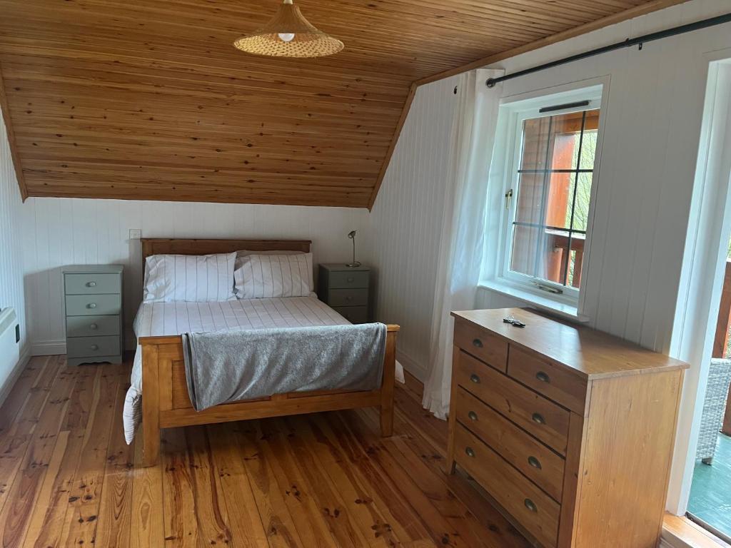 um quarto com uma cama, uma cómoda e uma janela em Large Newly Refurbished Lakeside Chalet With Optional Hot Tub & Boat Hire em Duneena