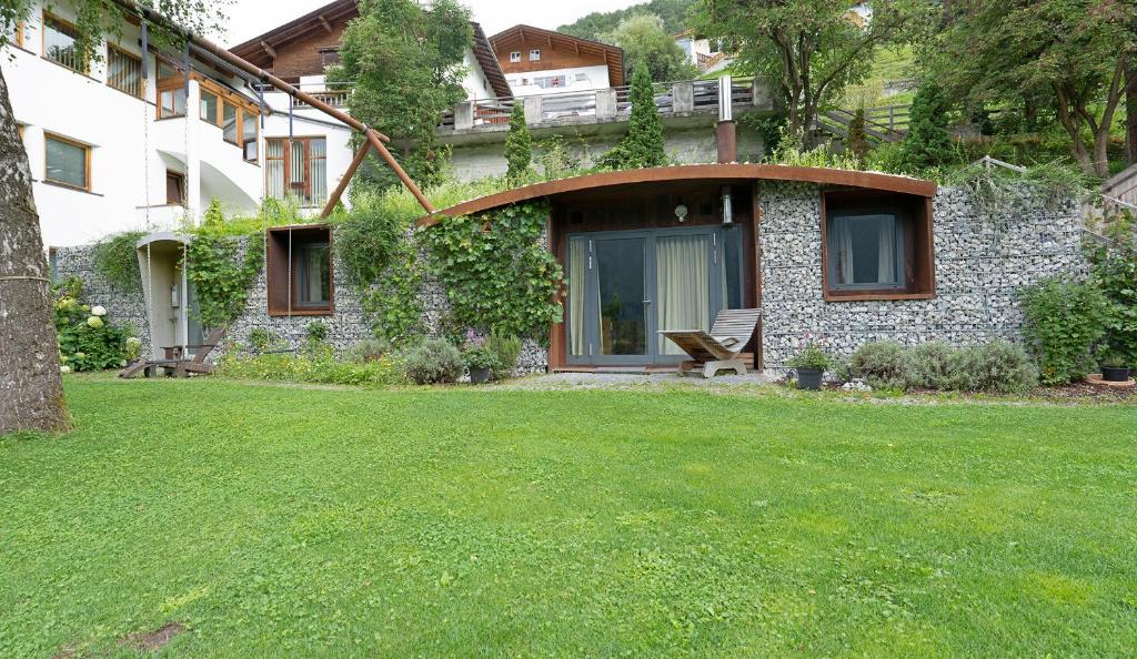 a stone house with a bench in a yard at Gurgltal Refugia in Tarrenz