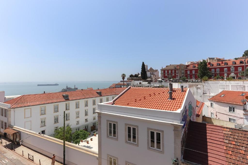 uma vista para uma cidade com edifícios e o oceano em Alfama River View Tailor Made Flat em Lisboa