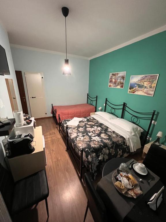 a room with two beds and a living room with a couch at B&B I' Chivi in Incisa in Valdarno