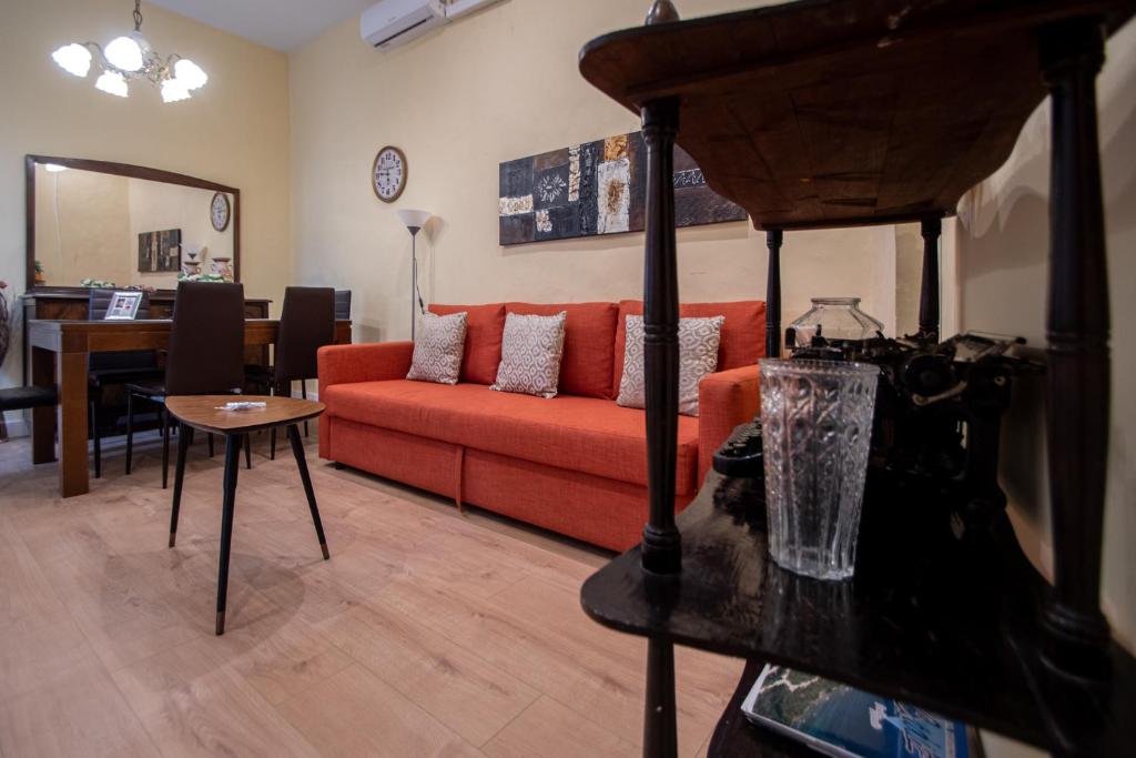 カディスにあるApartamento Casa Senorial Cadizのリビングルーム(赤いソファ、テーブル付)
