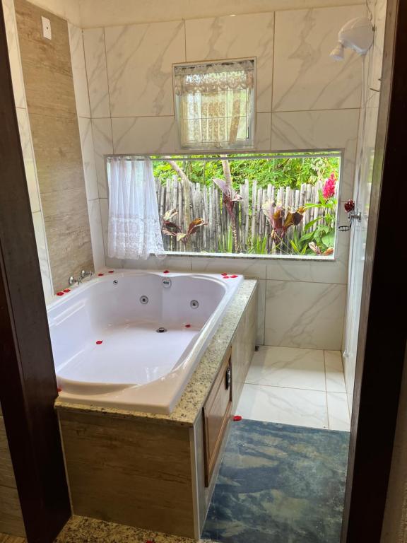 a large tub in a bathroom with a window at Pousada Kafofinho da Serra in Serra do Cipo