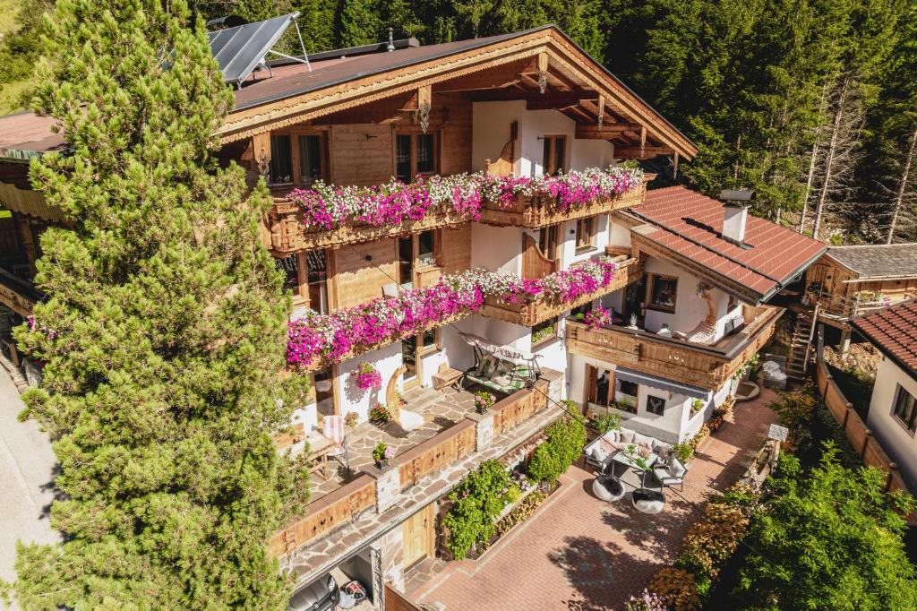 eine Luftansicht eines Hauses mit Blumen auf den Balkonen in der Unterkunft Gästehaus Waldruh in Gerlos