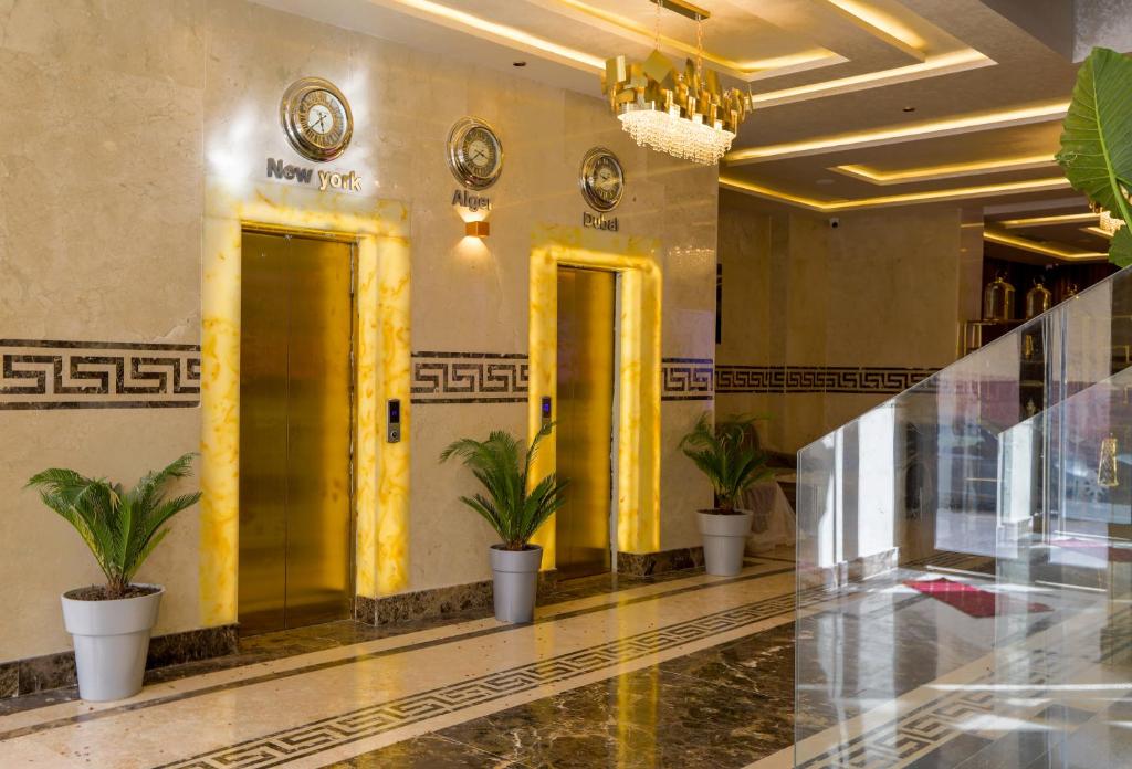 un hall avec deux portes jaunes et des plantes en pot dans l'établissement Melissa Hotel, à Oran