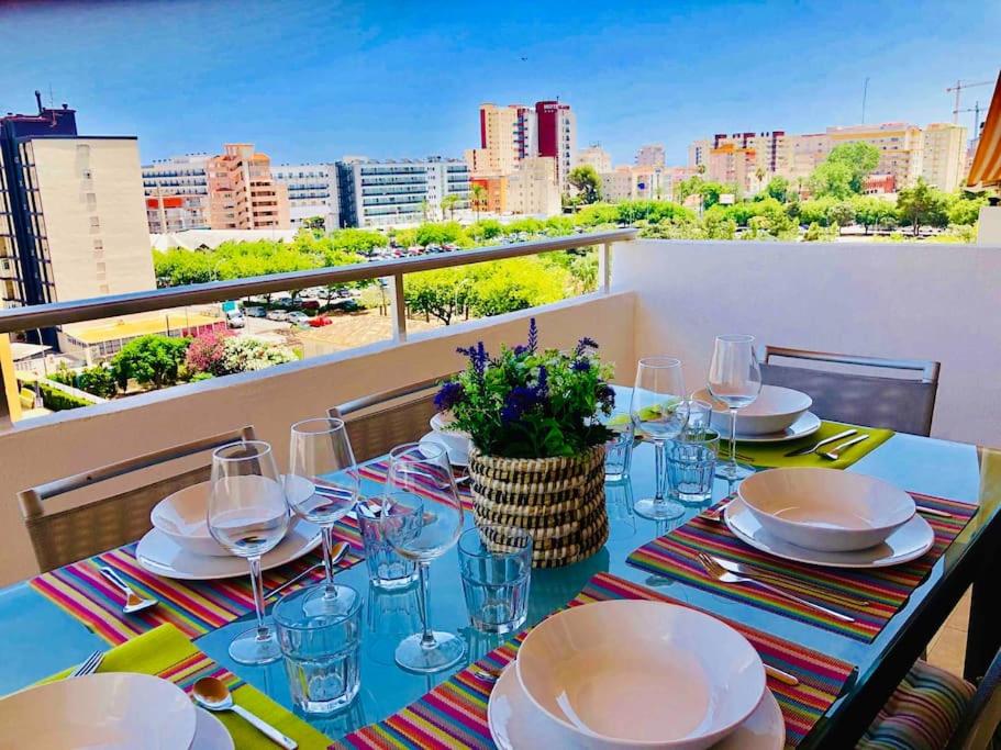 una mesa con platos y copas de vino en el balcón en Apartamento Gandia muy cerca de playa con piscina en Playa de Gandia