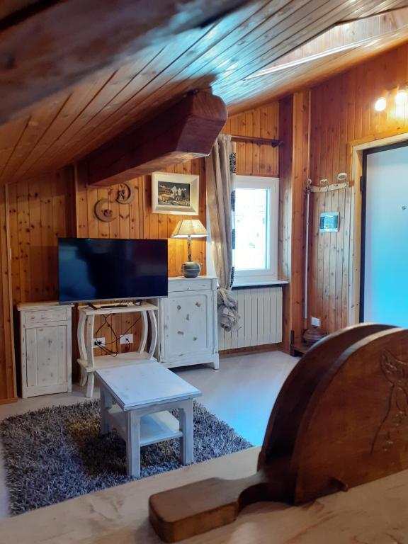 sala de estar con TV y mesa en Graziosa mansarda rustica - CIR VDA 0038, en Aosta