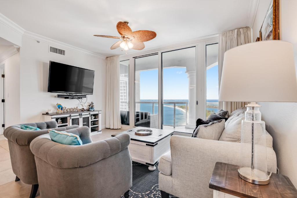 a living room with a couch and chairs and a tv at Portofino 4-1002 in Pensacola Beach