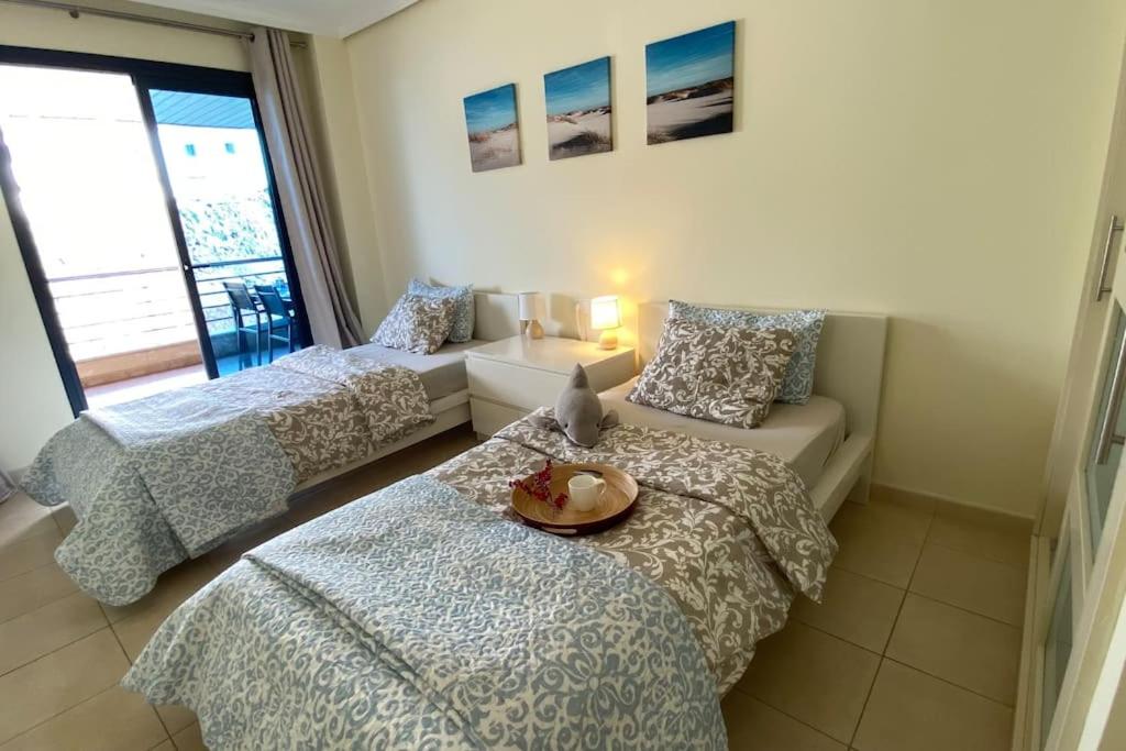 a bedroom with two beds and a table with a plate on it at Sea Harbor - Balcon de los Gigantes in Puerto de Santiago