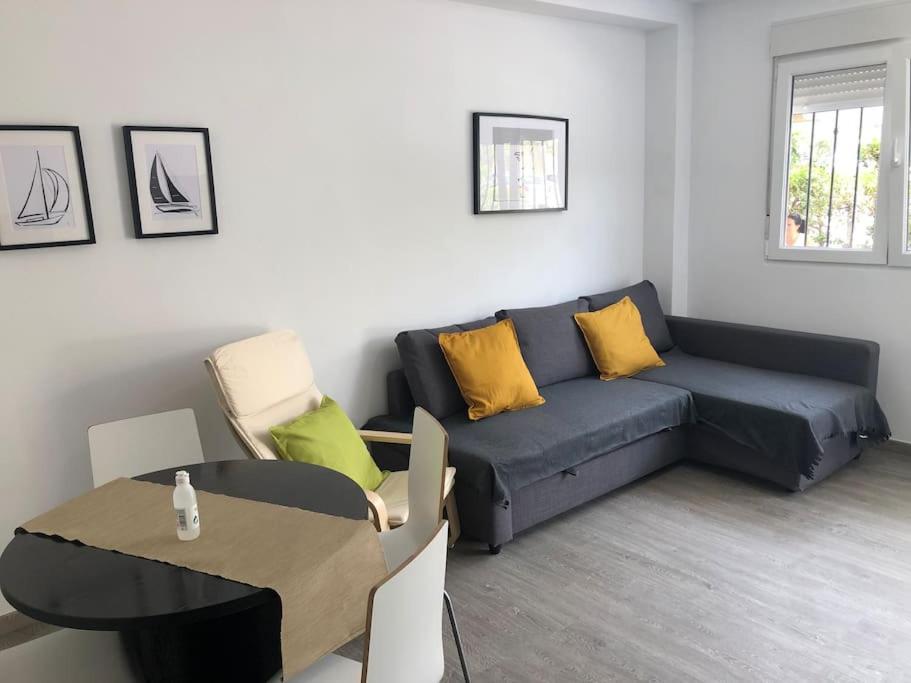 salon z niebieską kanapą i stołem w obiekcie La Carihuela Apartamento w mieście Torremolinos