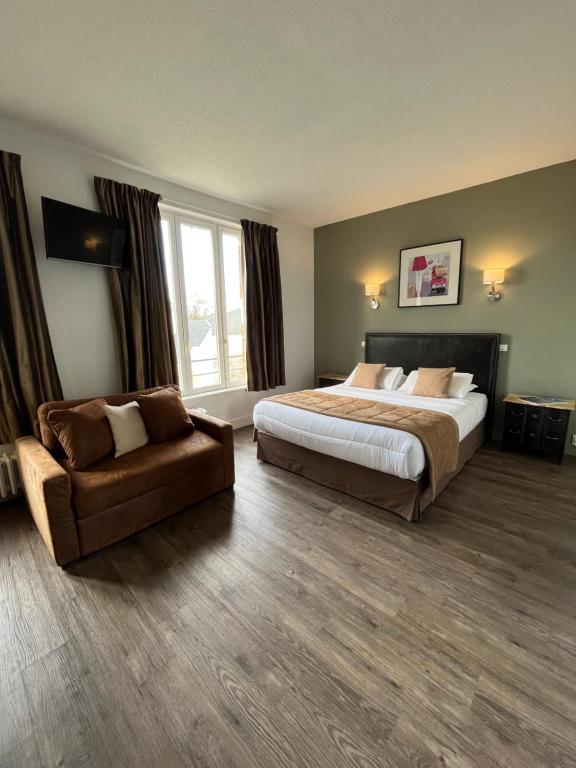 a hotel room with a bed and a chair at Hotel Des Cedres in Orléans