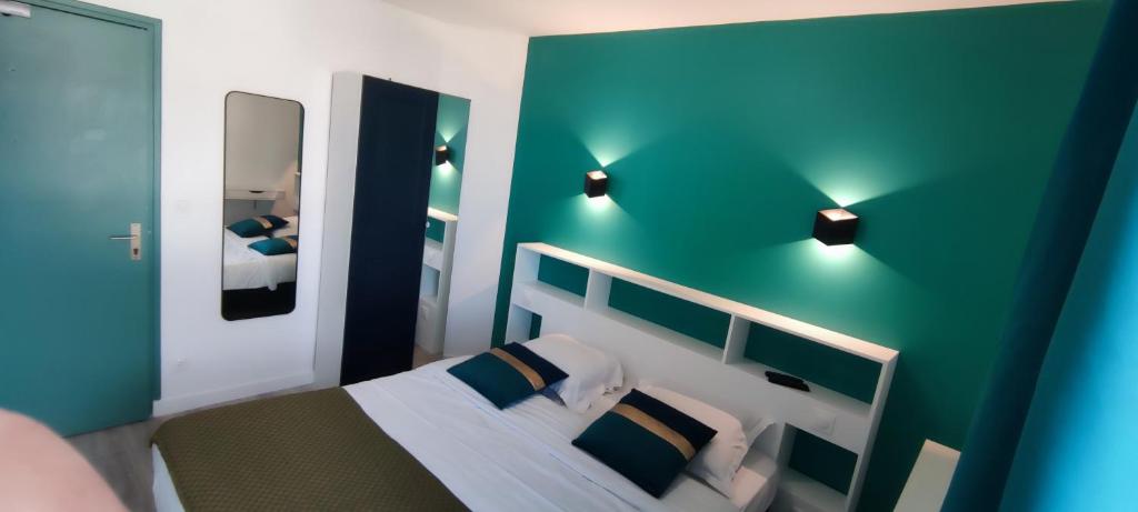 a bedroom with a bed with blue walls and lights at Hotel Des Bains in Veulettes-sur-Mer