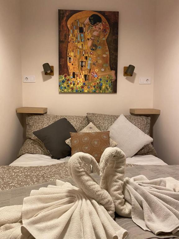 uma cama com uma toalha com um quadro em Mrs. Columbo's Flat em Budapeste