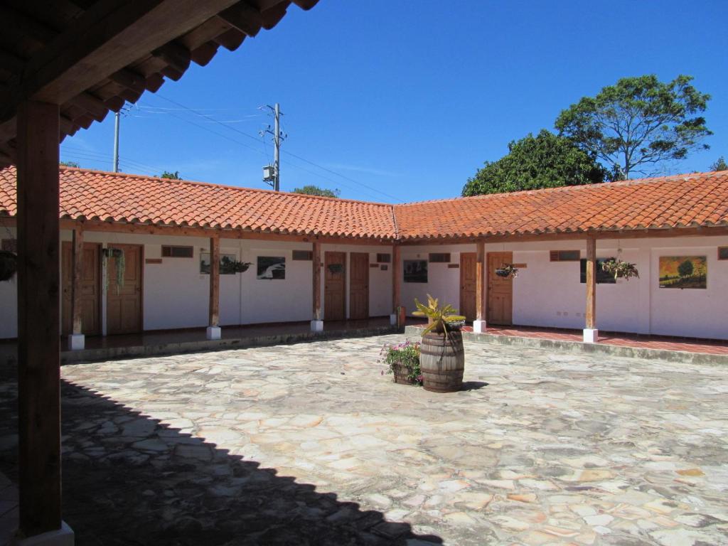 a building with a tile roof and a courtyard at Hotel Ecoposada Viña de Aldana in Los Santos