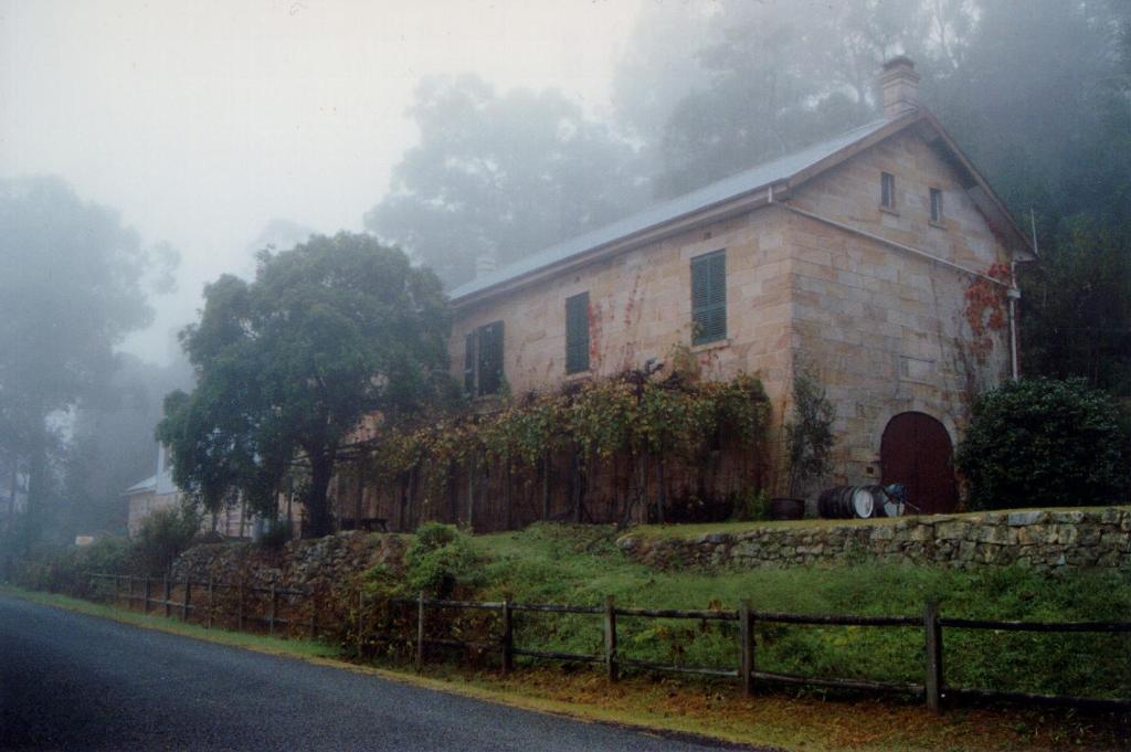 an old stone house on the side of a road at Tizzana Winery Bed and Breakfast in Sackville Reach