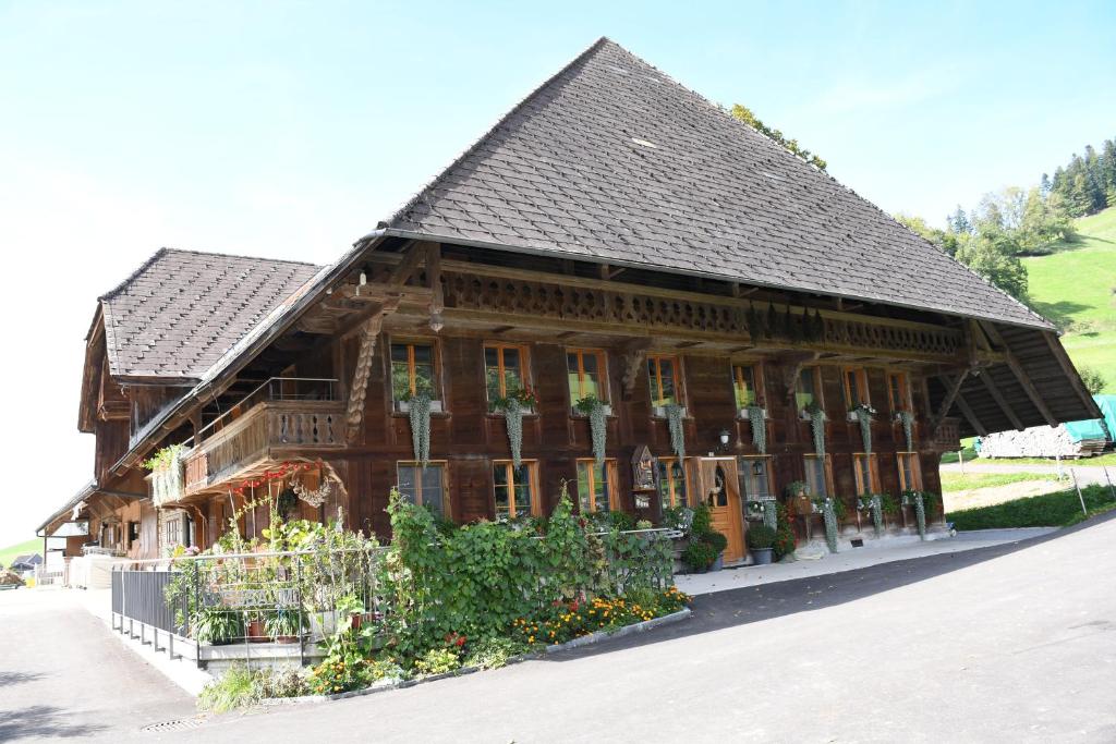a large wooden building with a black roof at Hof-Fankhauser in Wasen