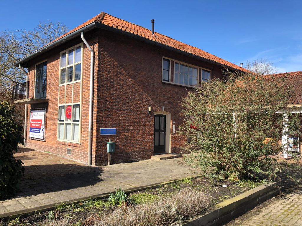 a red brick house with a black door at IJsselmeer appartement in Andijk