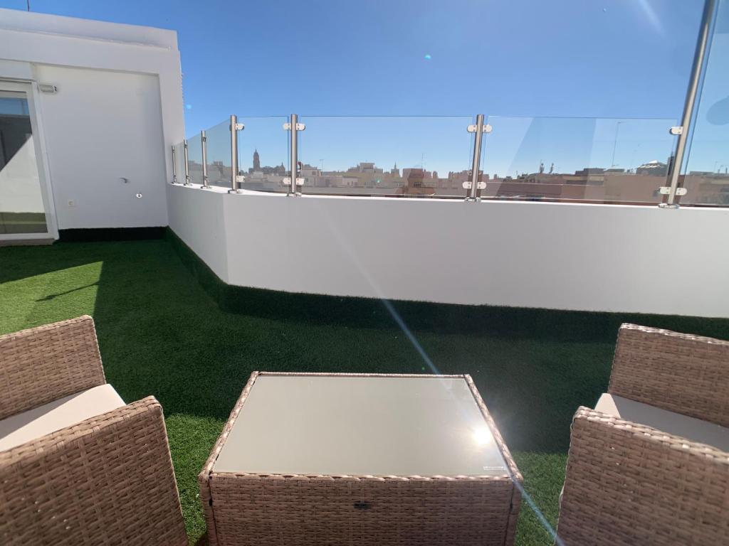 einen Tisch und Stühle auf einem Balkon mit Aussicht in der Unterkunft Ático Mármoles - Centro Málaga in Málaga