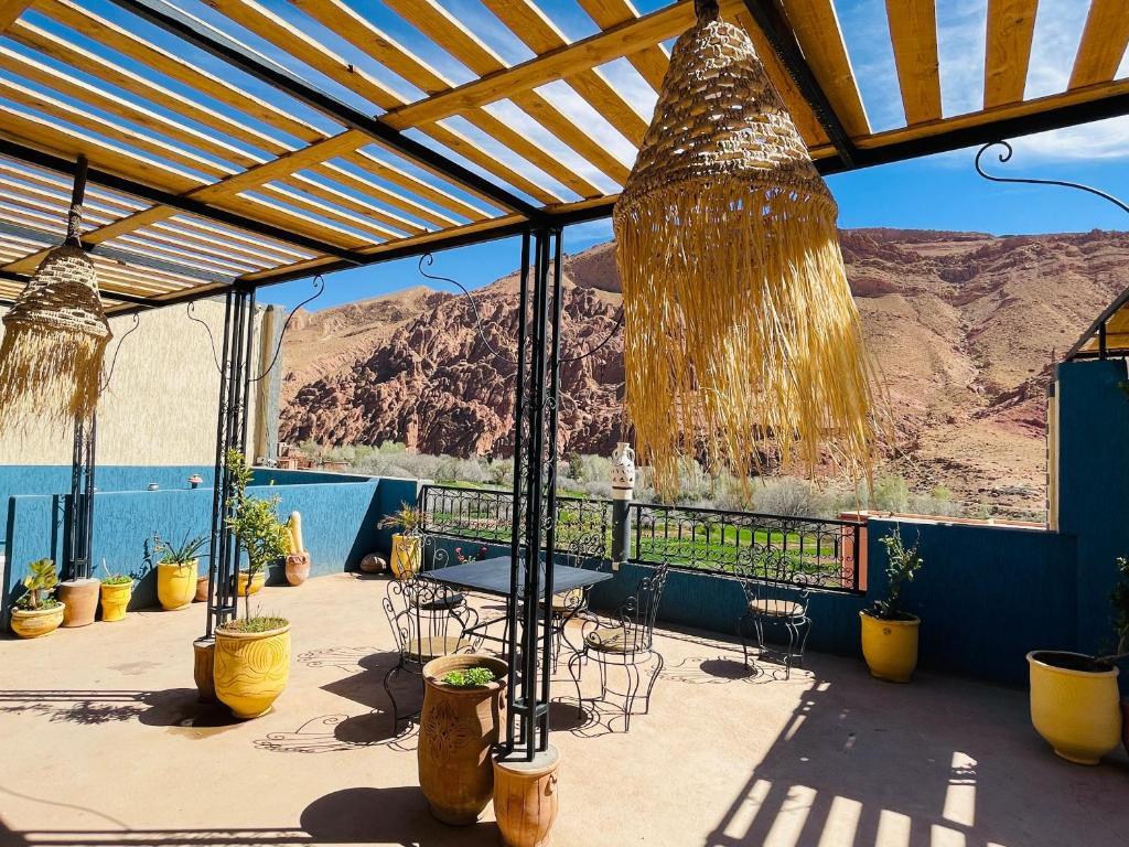 eine Terrasse mit einem Tisch und Stühlen sowie Bergblick in der Unterkunft Hiking Nomads Guesthouse in Tamellalt