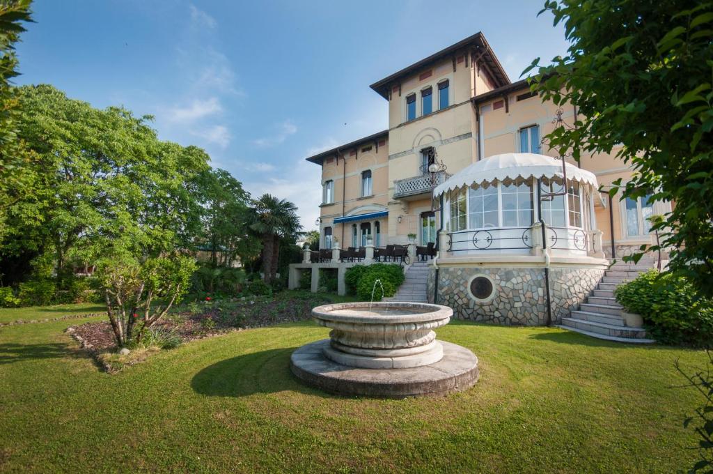 a large building with a fountain in the yard at Hotel Villa Maria in Desenzano del Garda