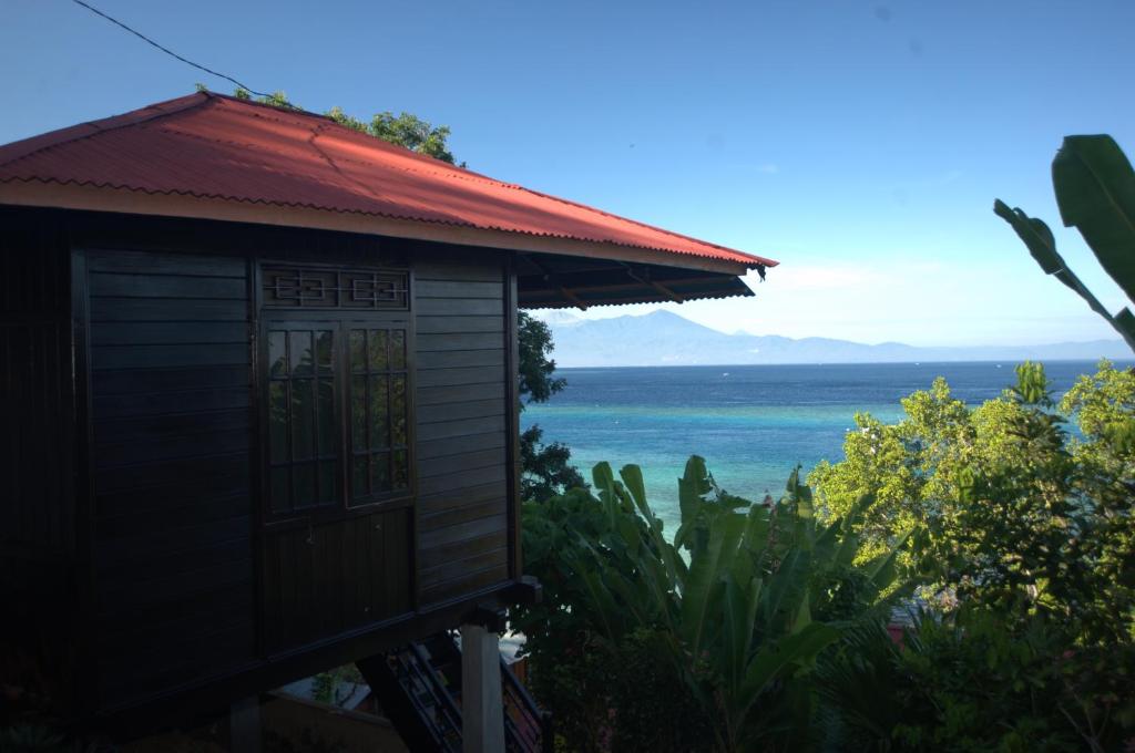 un pequeño edificio con vistas al océano en Happy Gecko Dive Resort en Bunaken