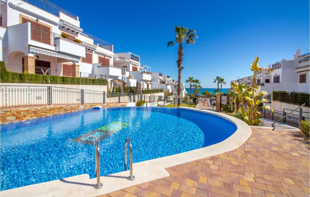 a swimming pool in front of some apartment buildings at Cozy Apartment In Torrevieja With Wifi in Torrevieja