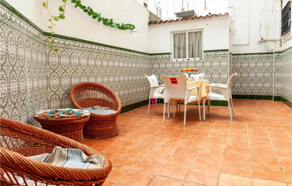 un patio con sillas de mimbre y una mesa en un patio en 3 Bedroom Nice Apartment In Huelva en Huelva