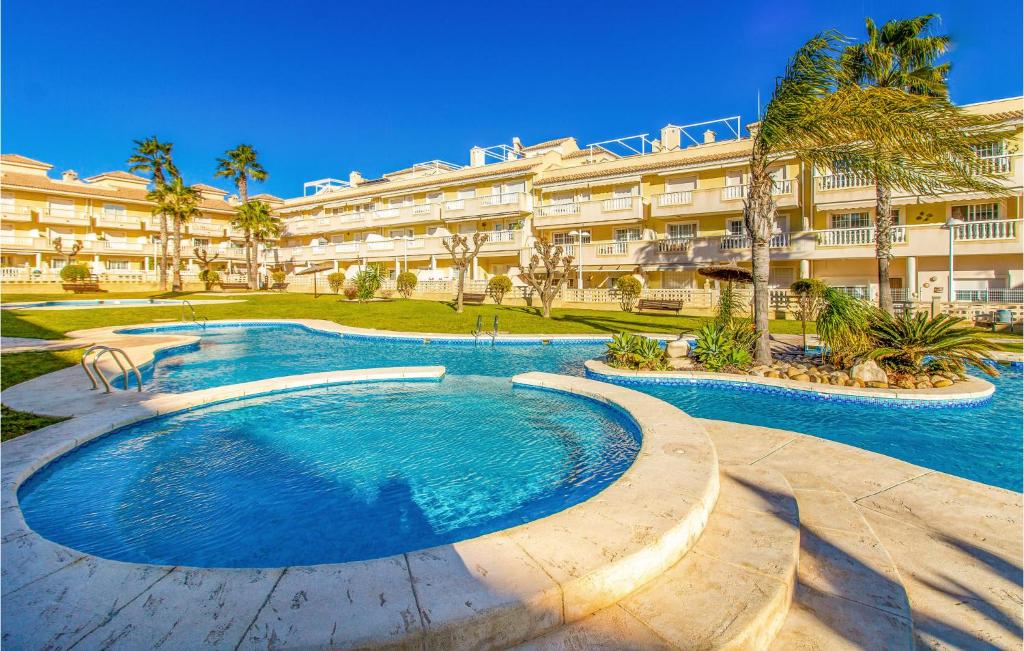 einem Pool vor einem großen Gebäude in der Unterkunft Stunning Apartment In Santa Pola With Outdoor Swimming Pool in Santa Pola